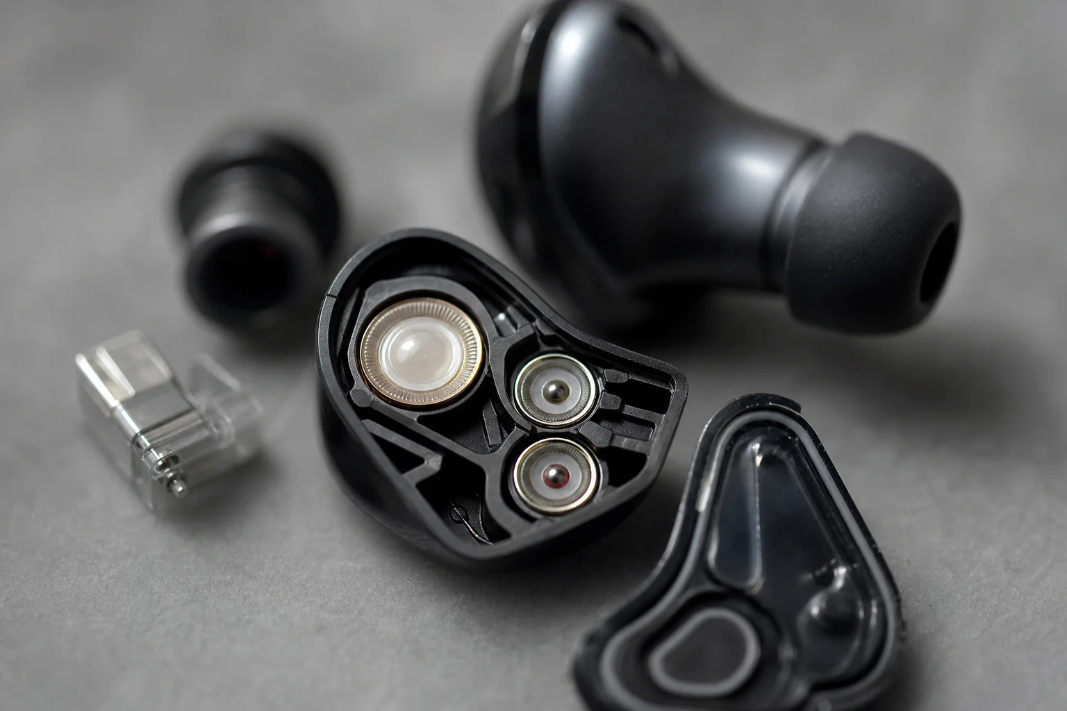 Primer plano de los componentes del transductor de los auriculares que muestra el diseño acústico interno