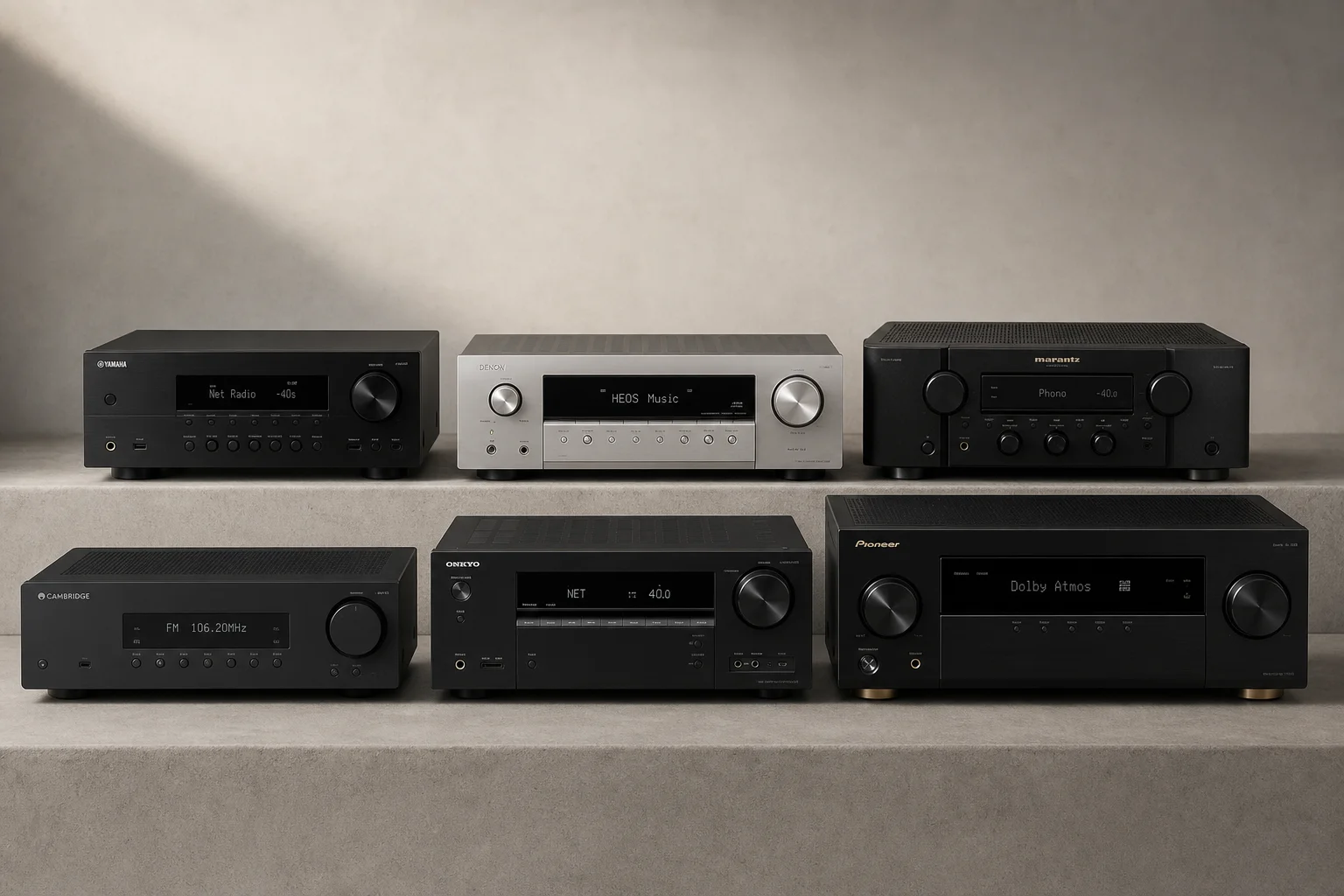 Six stereo receivers arranged on concrete surface showing various sizes and designs