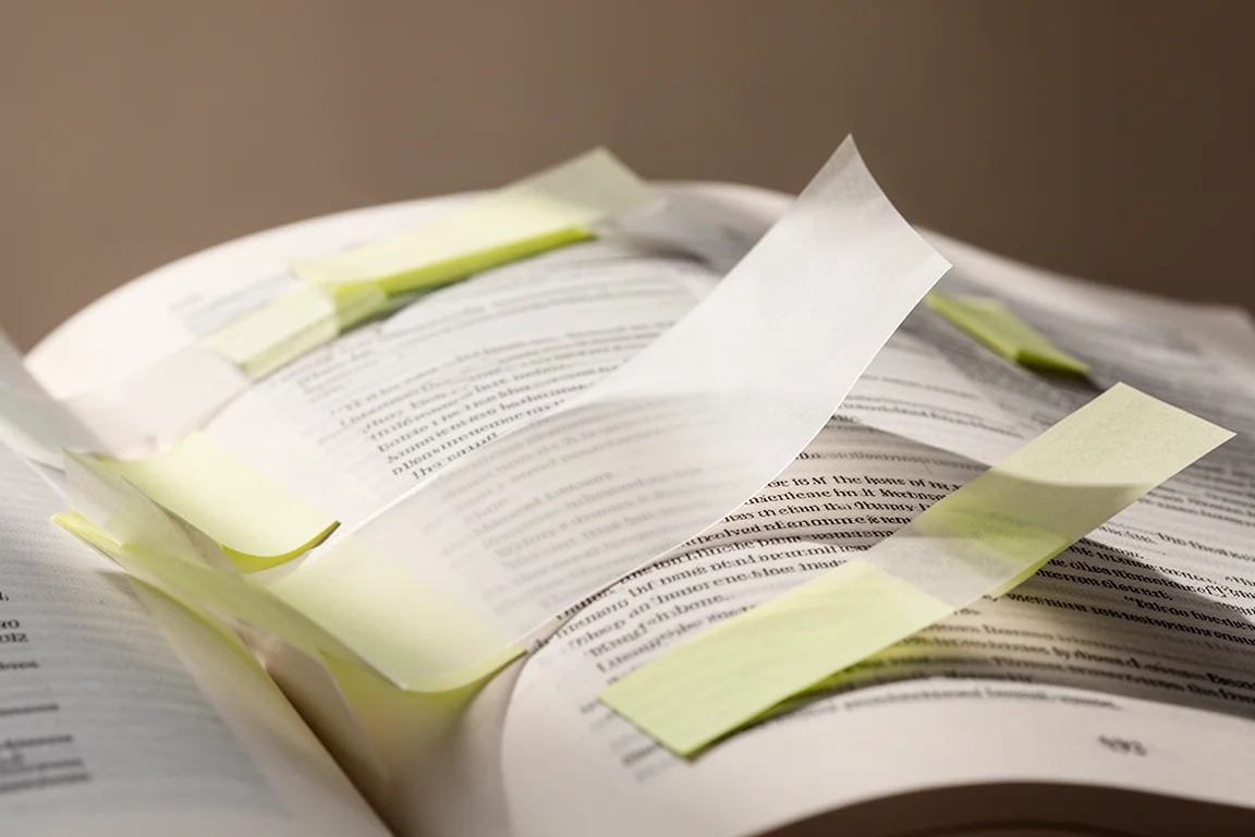 Doorzichtige sticky notes die pagina's van een open boek markeren