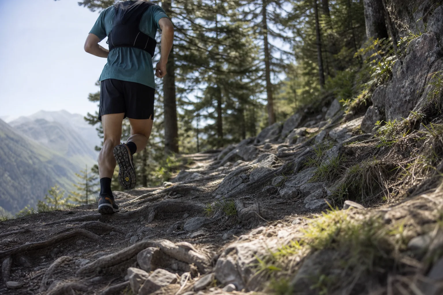 Trailrunner auf einem felsigen Bergpfad mit Wurzeln und unebenem Gelände