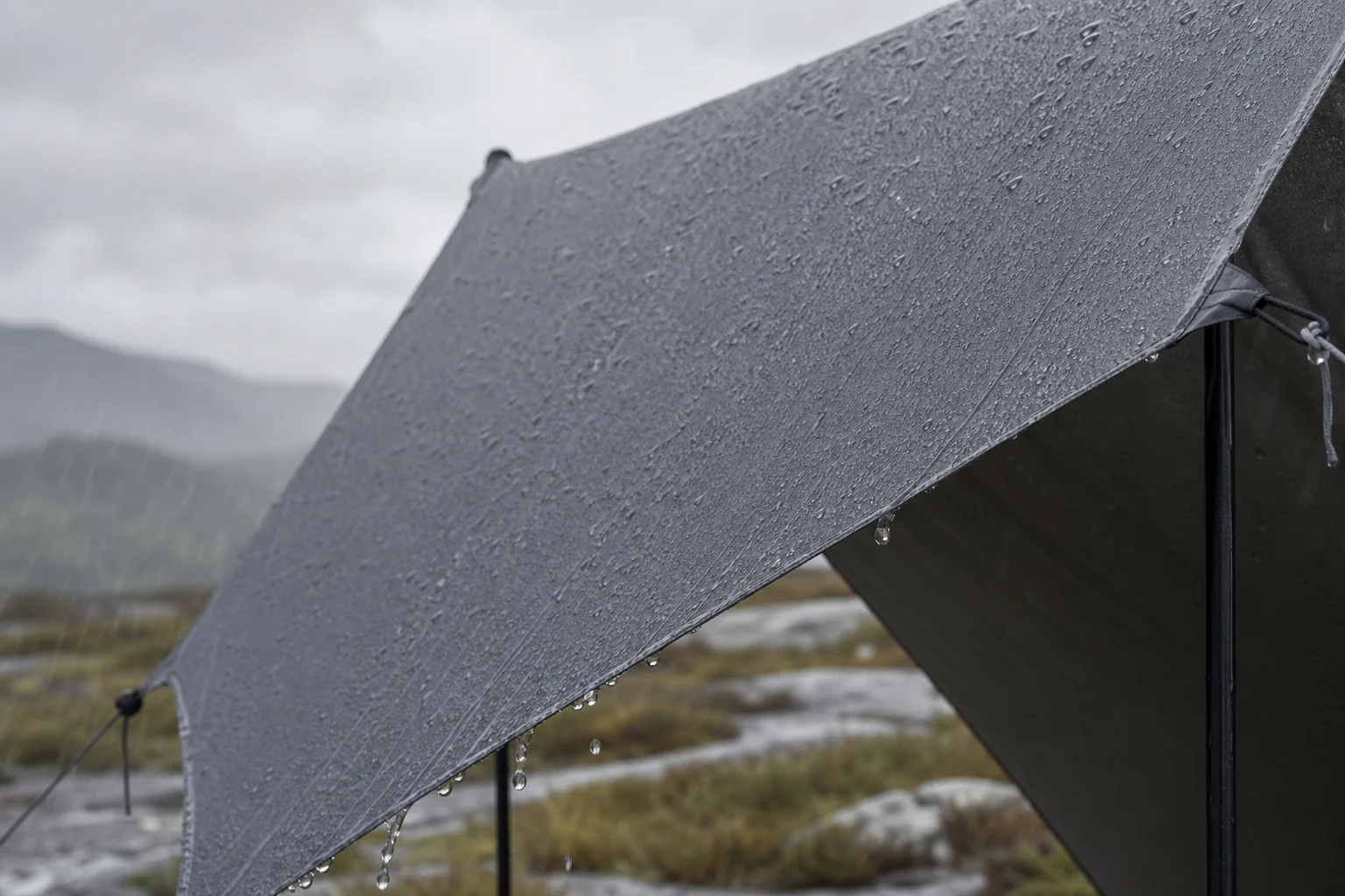 Tarp shelter providing protection during heavy rain with water beading on fabric