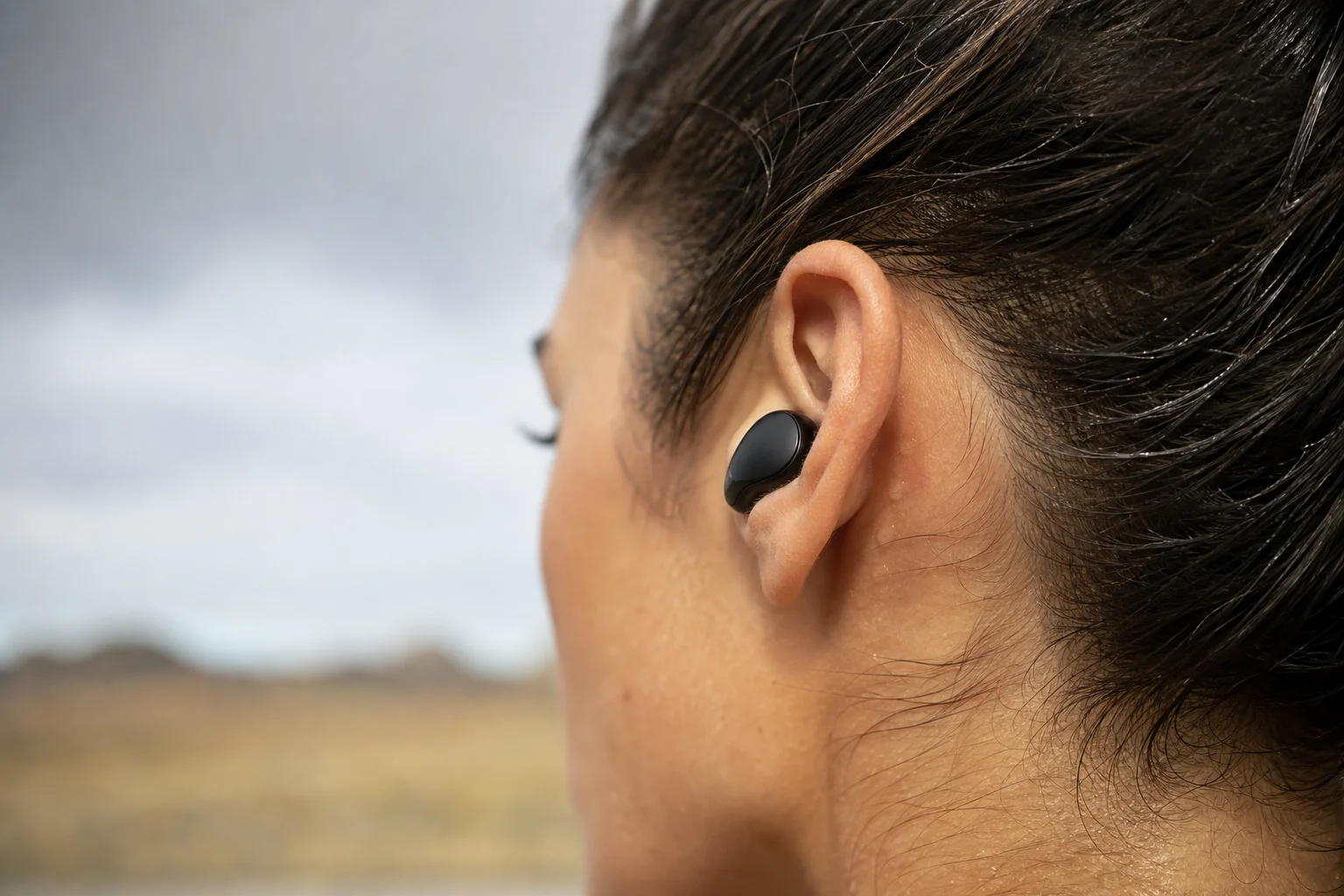 Gros plan sur l'ajustement et le confort des écouteurs dans une oreille humaine lors d'une activité en extérieur