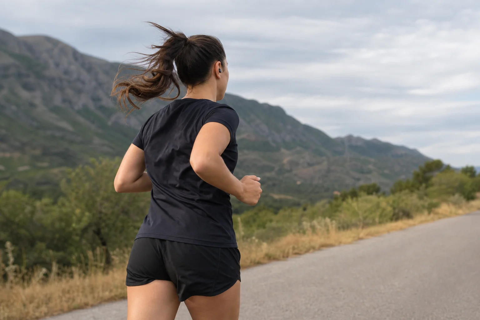 Coureur portant des écouteurs pendant un entraînement en extérieur à la lumière du jour