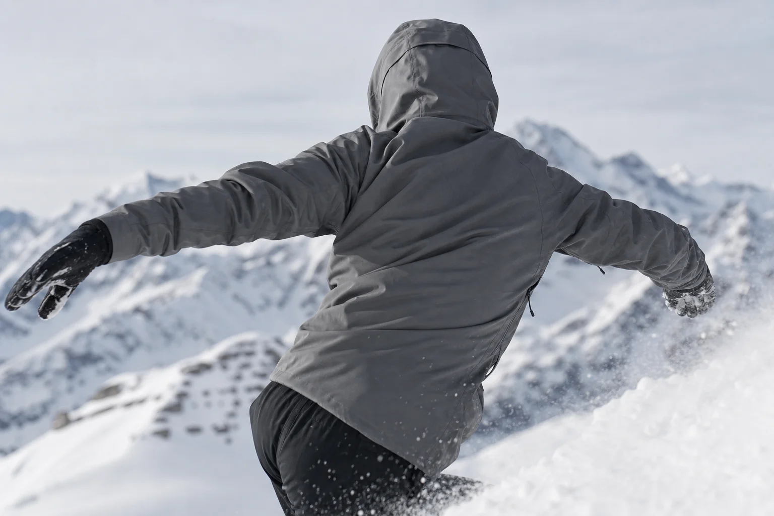 Atleta con chaqueta elástica moviéndose dinámicamente en una ladera nevada