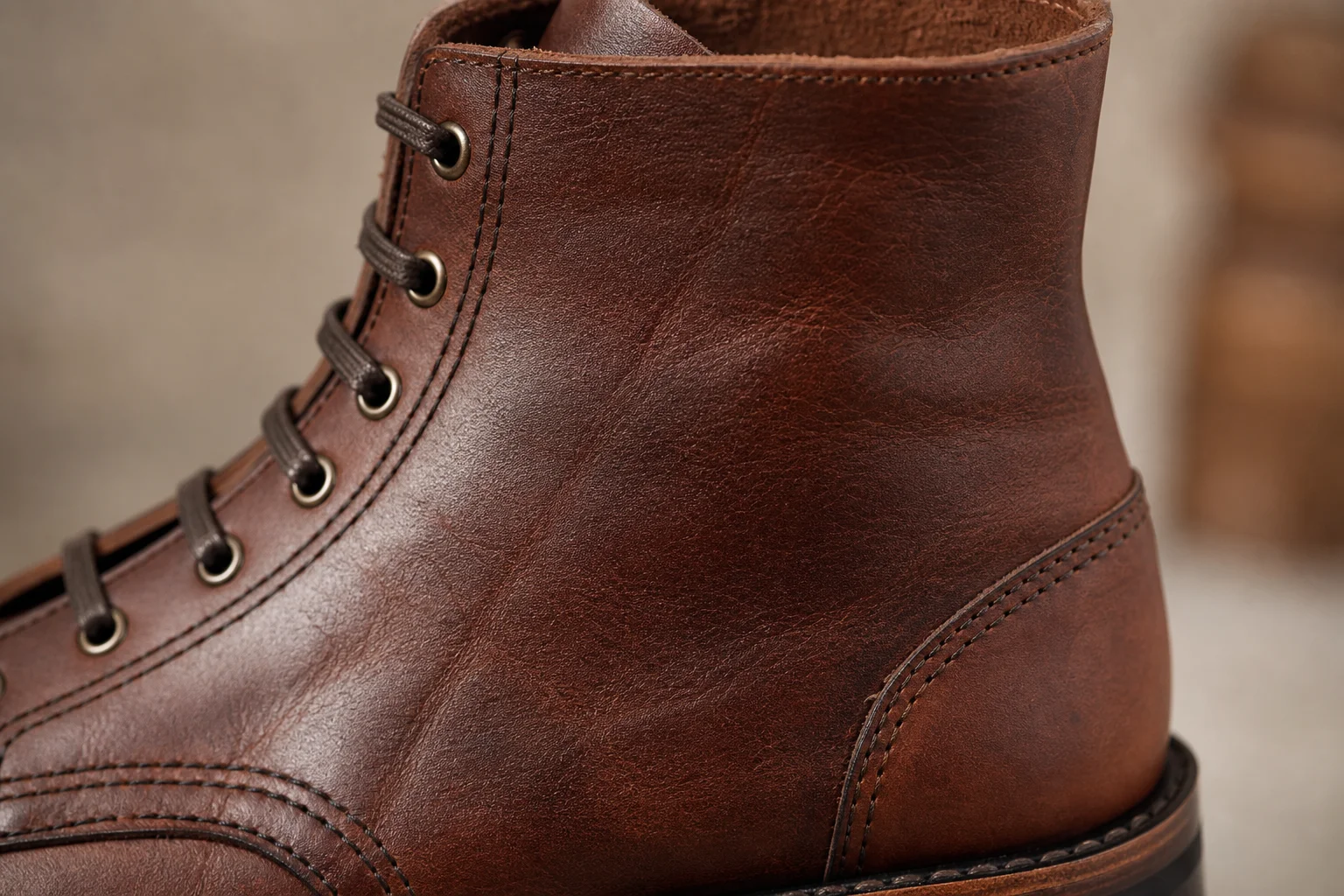 Gros plan sur le cuir et les coutures d'une botte illustrant le savoir-faire