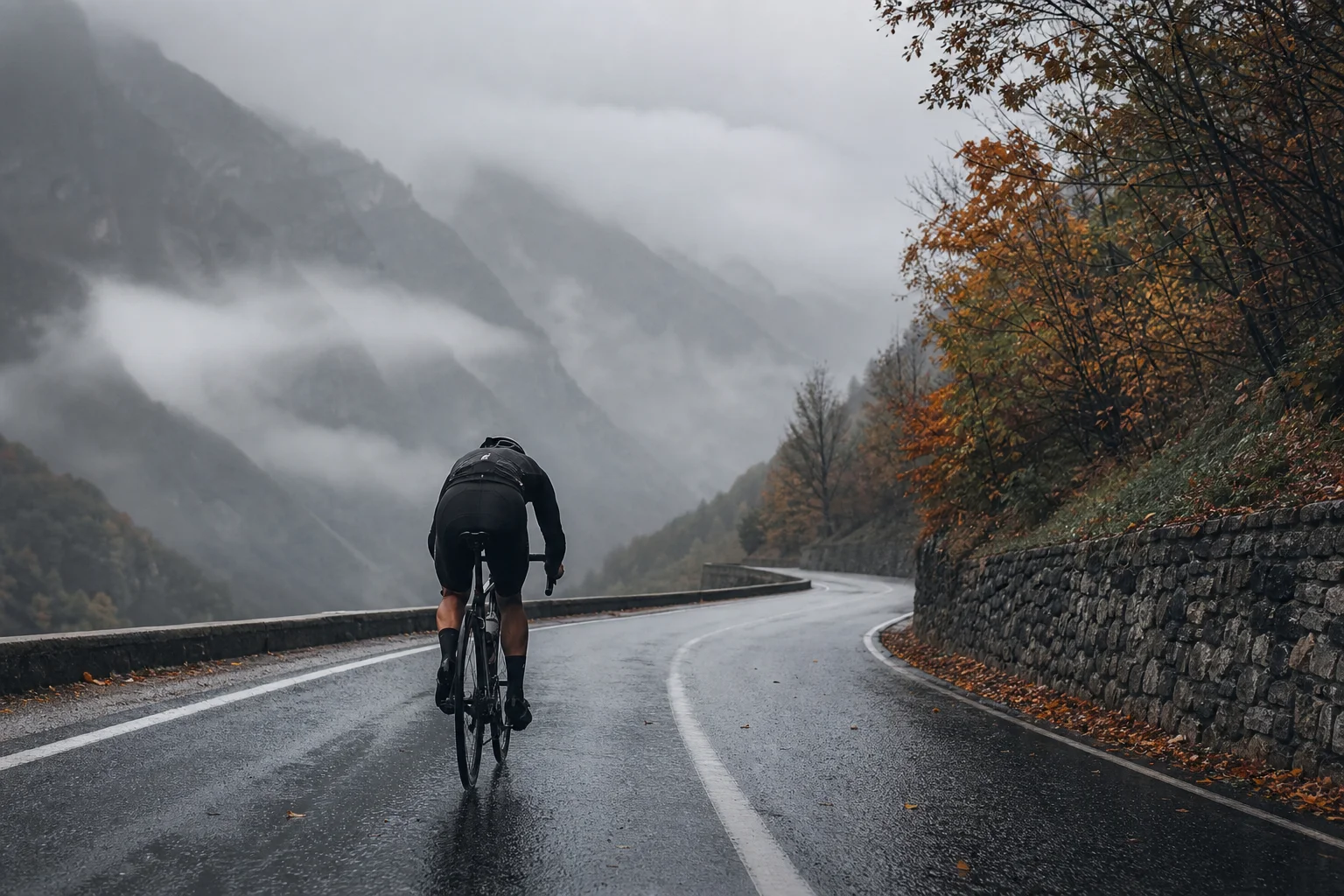 Radfahrer auf einer nassen Herbststraße bei Regen und bewölktem Himmel