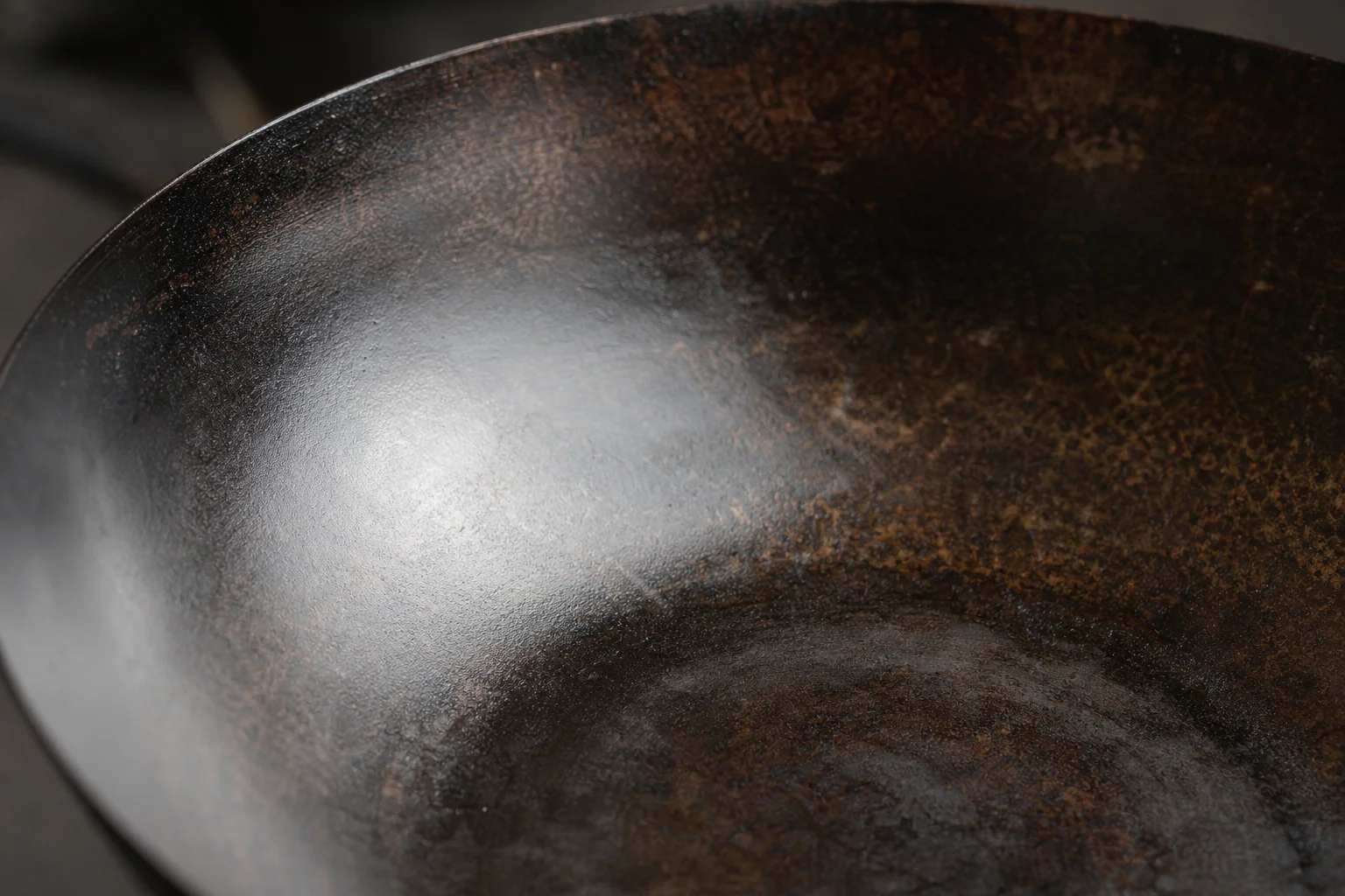 Close-up of a wok's interior showing seasoned patina and natural non-stick surface