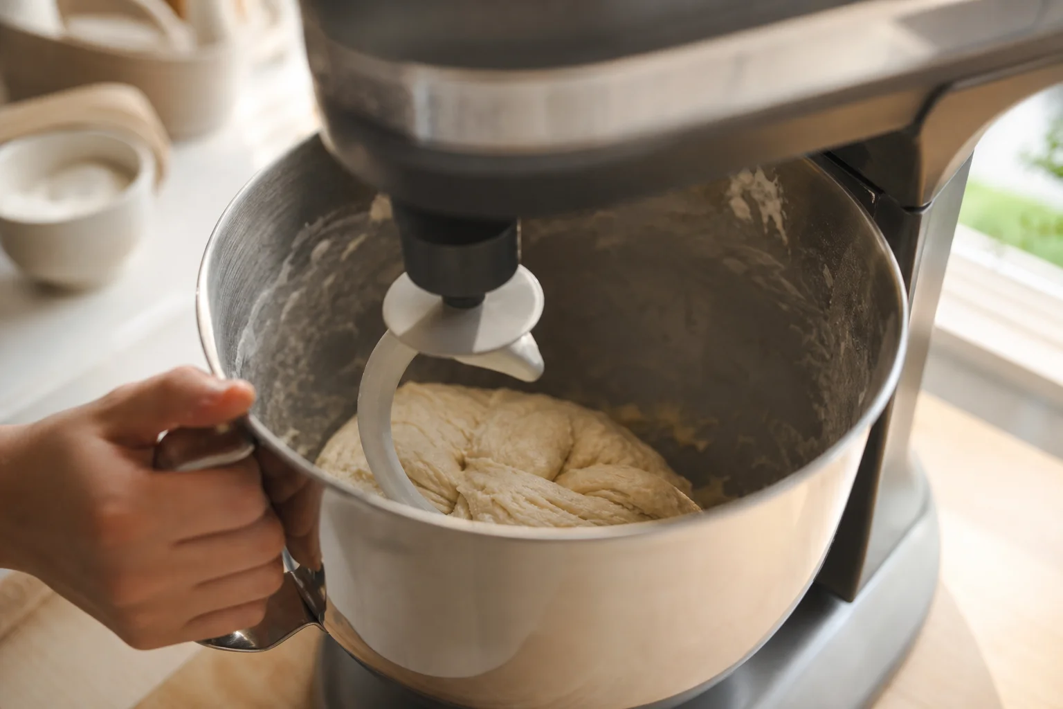 Stand mixer bowl with whipped cream and metal beaters in action