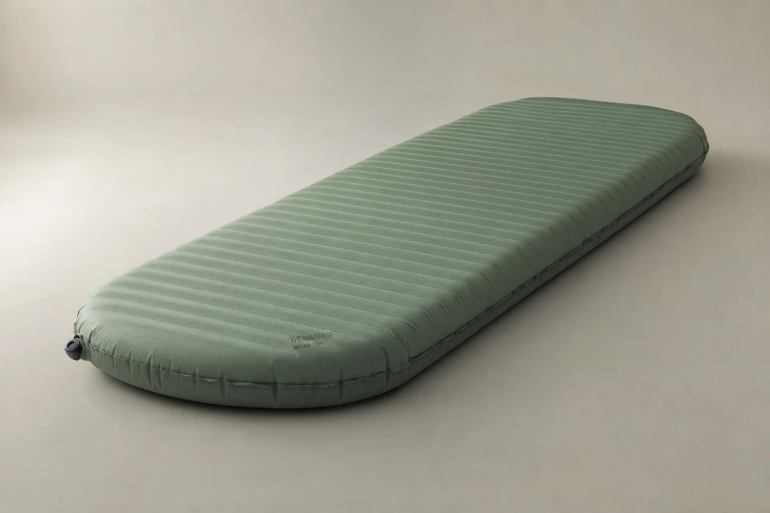 Siete colchonetas de dormir dispuestas sobre una superficie de hormigón que muestran desde opciones ultraligeras hasta opciones de longitud completa