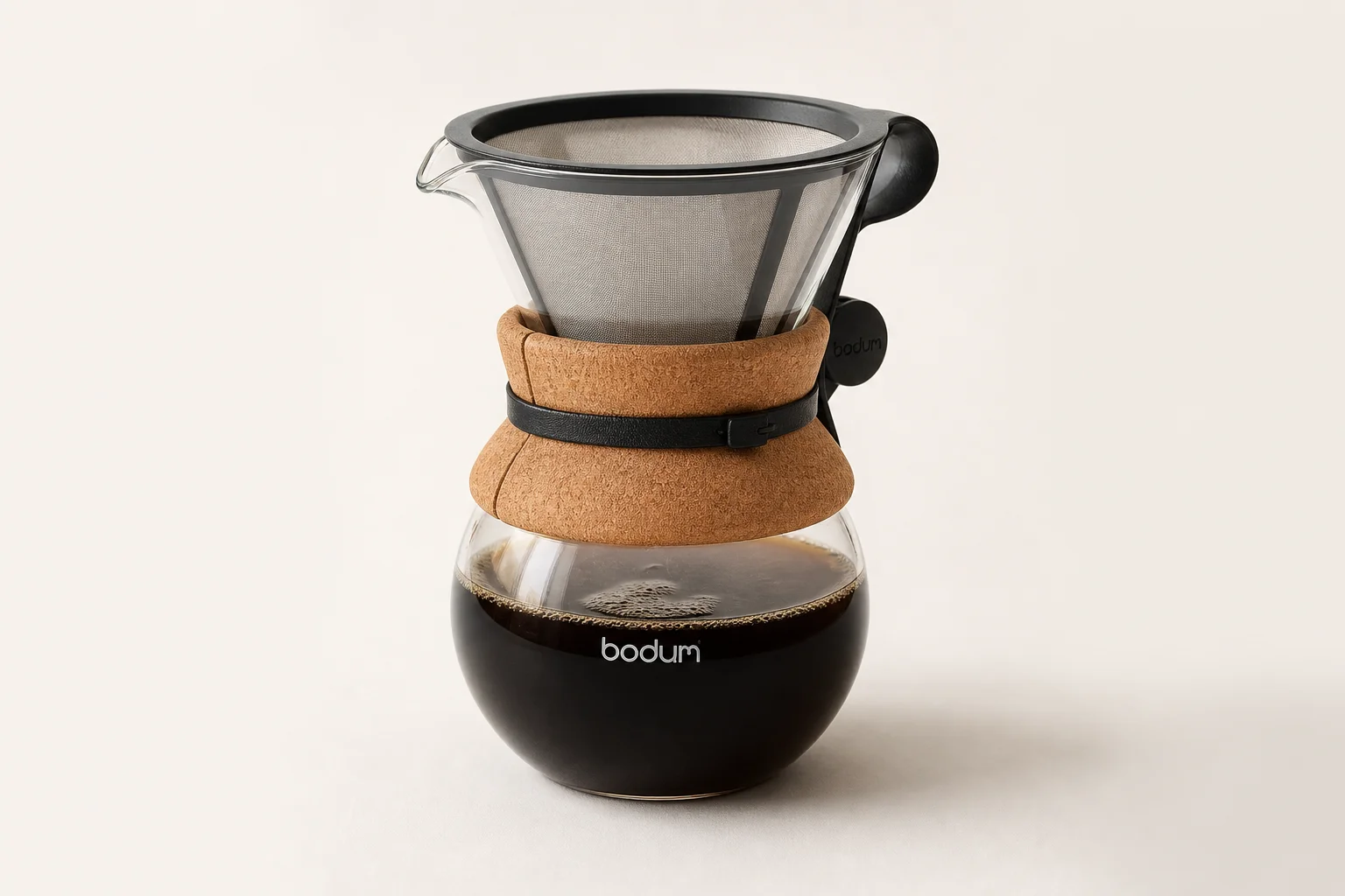 Five pour over coffee makers arranged on concrete surface showing variety of styles and designs