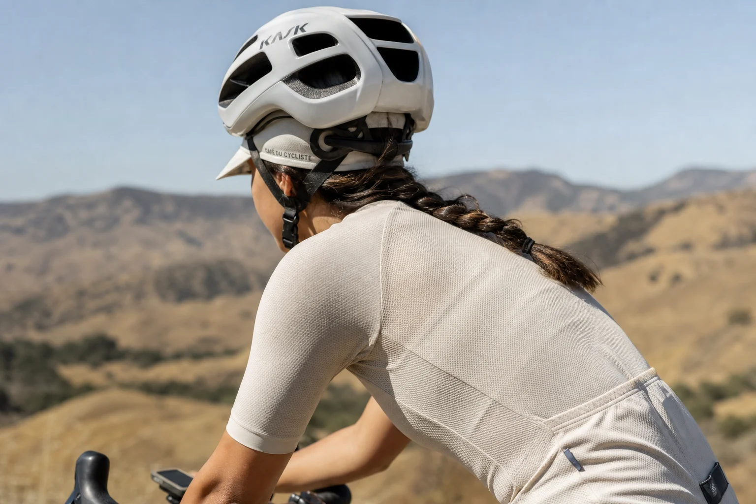 Cyclist wearing a cycling cap under a helmet on a sunny day