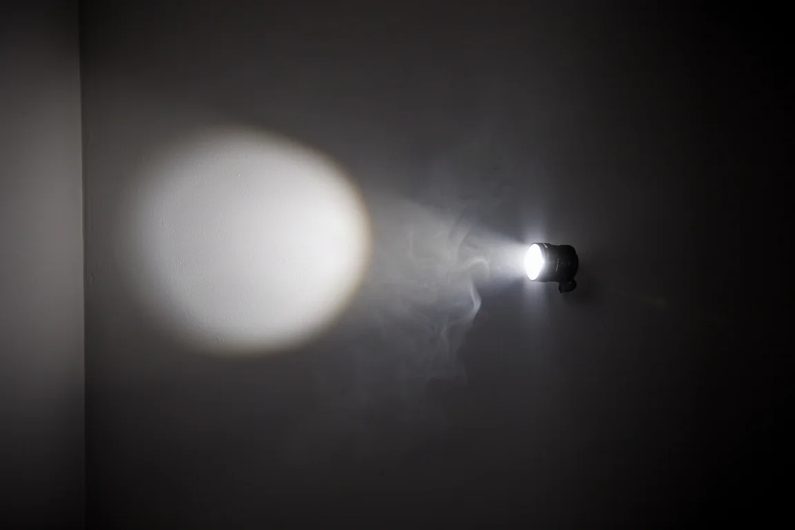 Flashlight beam patterns compared on a dark wall at night
