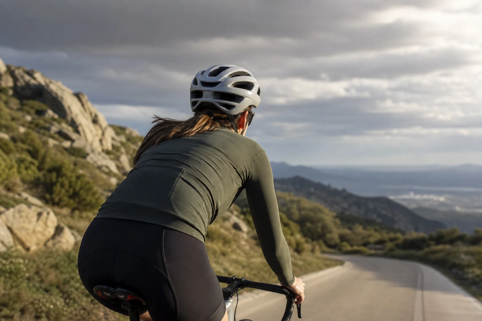 Ciclista che pedala in condizioni di luce variabile mostrando la ventilazione del casco