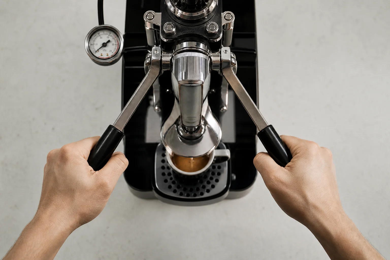 Hände bedienen die Hebelarme einer manuellen Espressomaschine, wobei das Manometer sichtbar ist