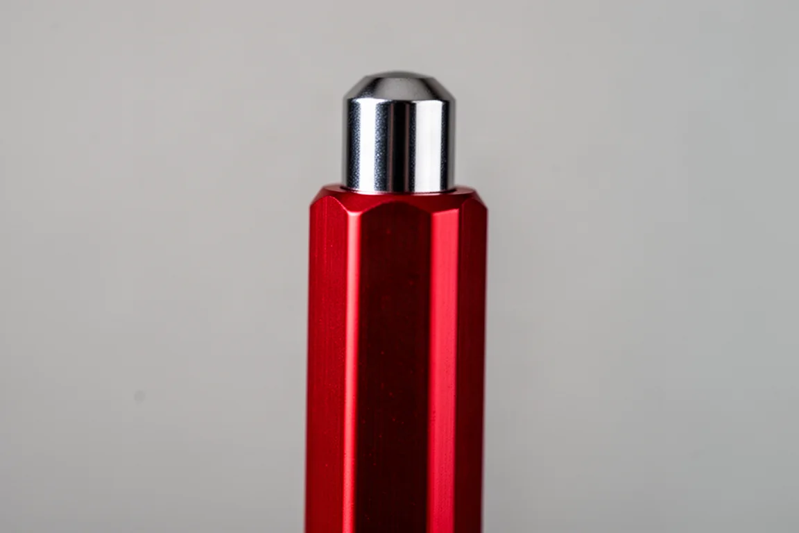 Close-up of a slim aluminum pen barrel showing its hexagonal profile