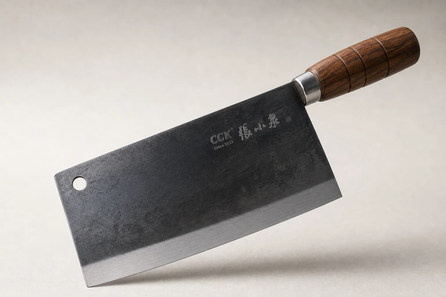 Professional kitchen knives and tools arranged on concrete surface