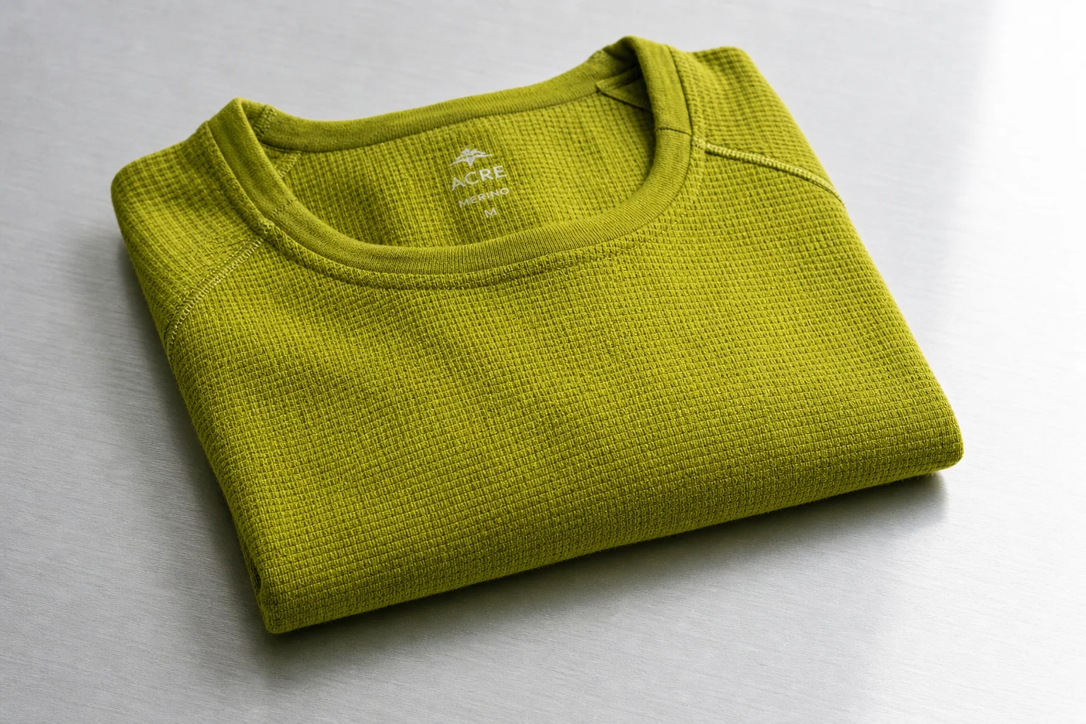 Cinq produits de course hivernale disposés sur du béton : chaussure imperméable, couche de base en mérinos, haut à quart de zip, écouteurs et sachet énergétique.