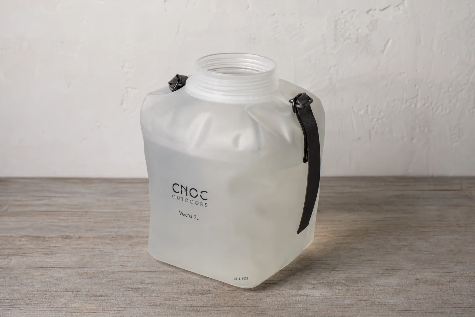Hiking backpack with water bladder and water bottle on concrete surface