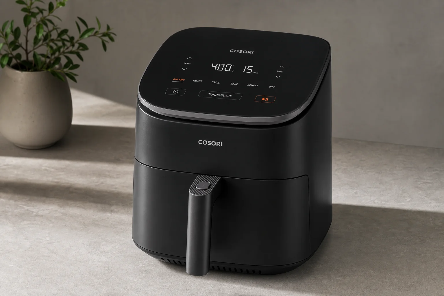 Seven air fryers of varying sizes and designs arranged on a neutral surface