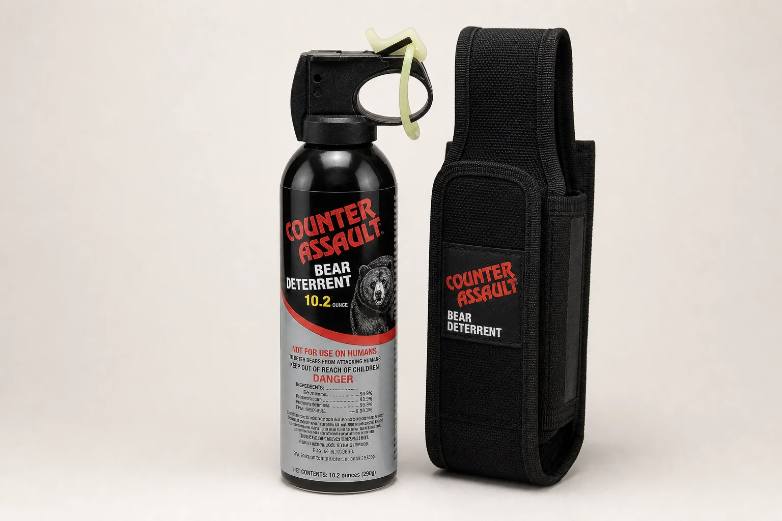 Five bear spray cans of varying sizes arranged on concrete surface