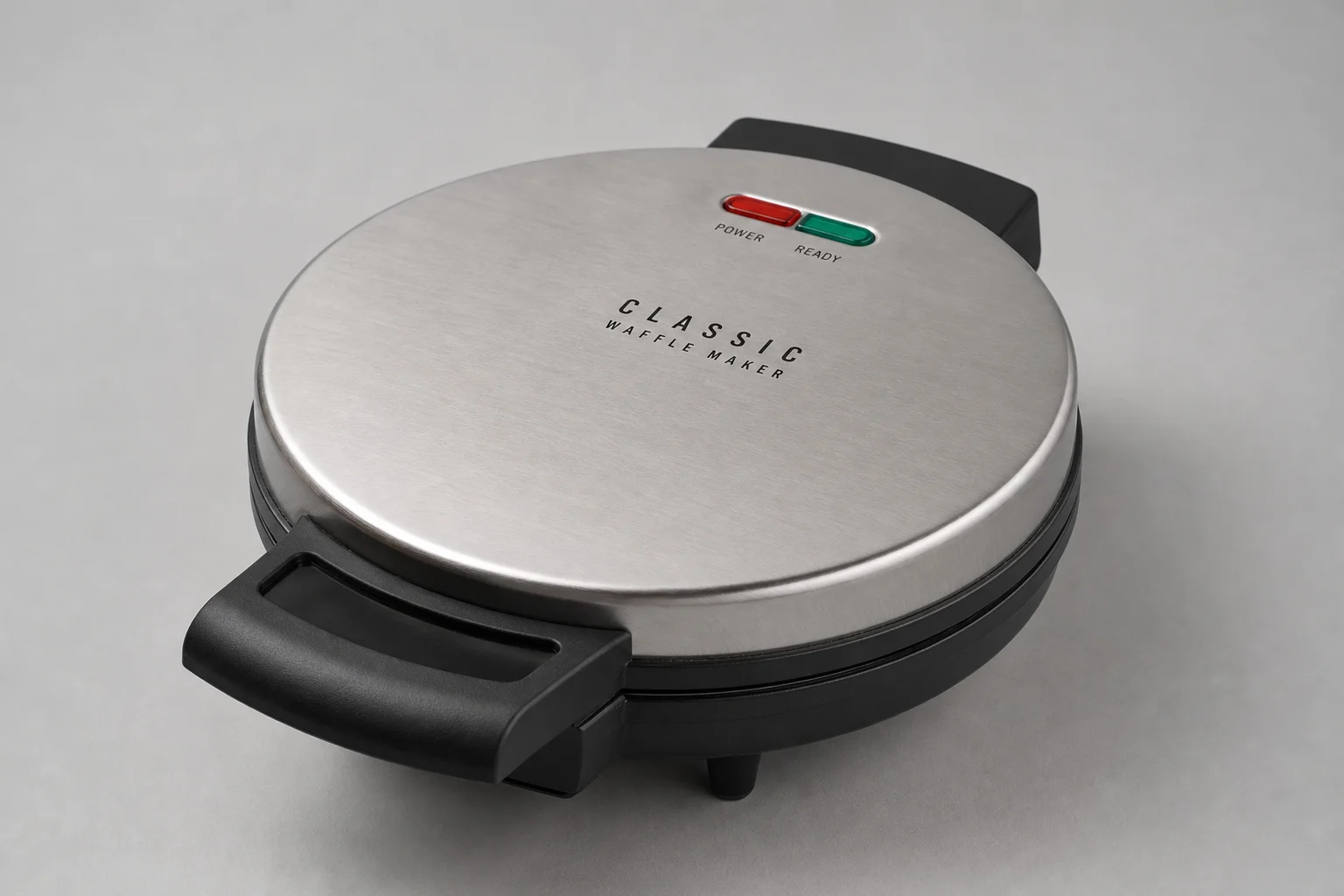 Cinq gaufriers Cuisinart disposés sur une surface en béton, du modèle économique au modèle haut de gamme