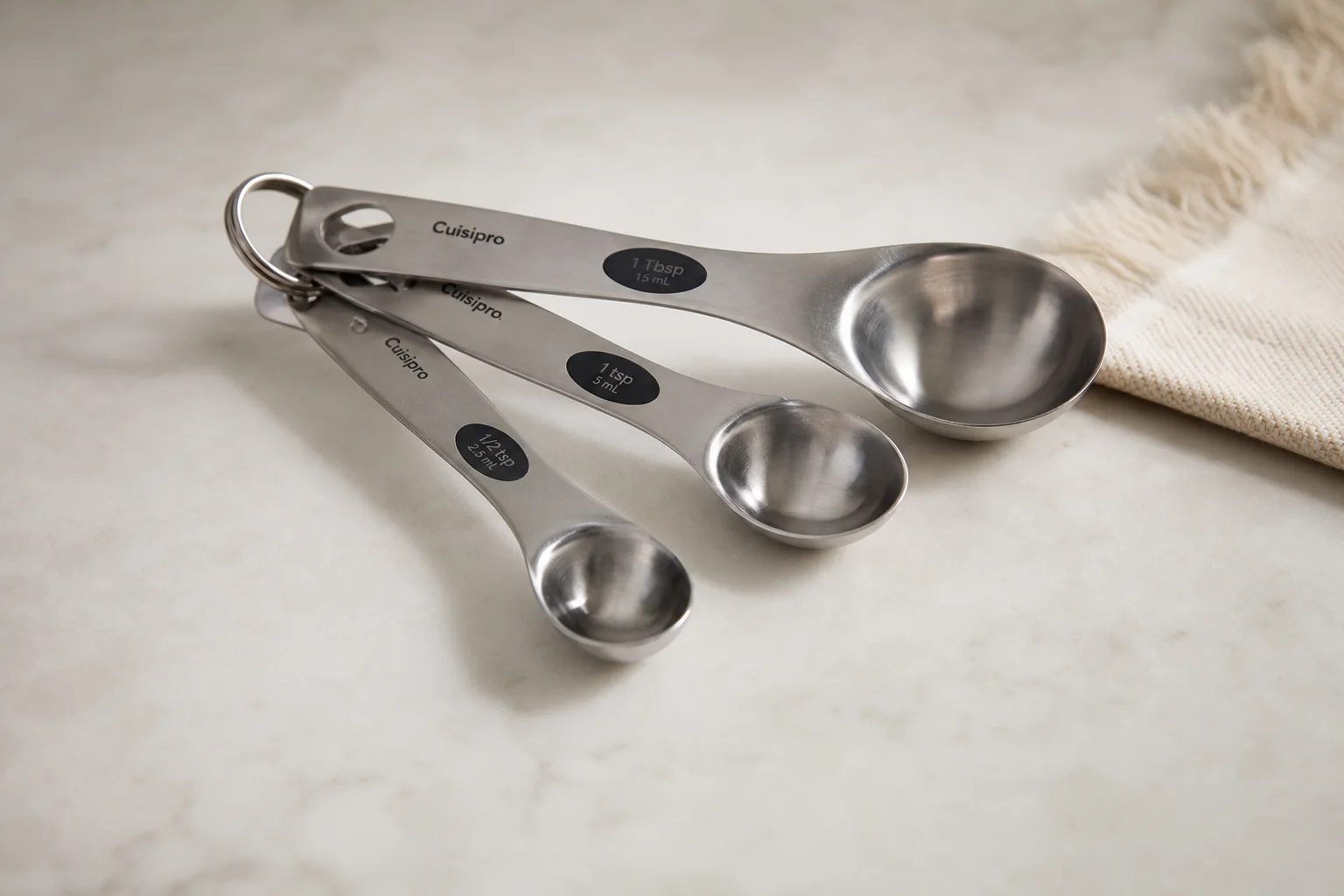 Eight essential kitchen tools arranged on a light wood surface