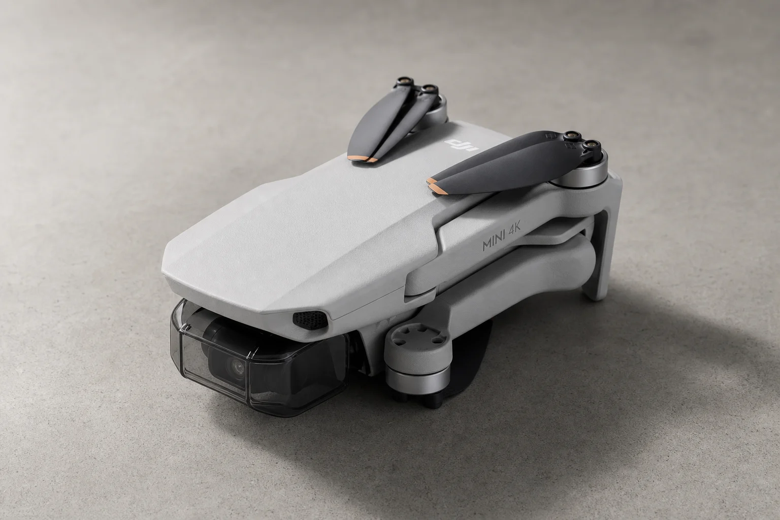 DJI Mini 4K 空拍機摺疊後放置於中性水泥地面的樣貌