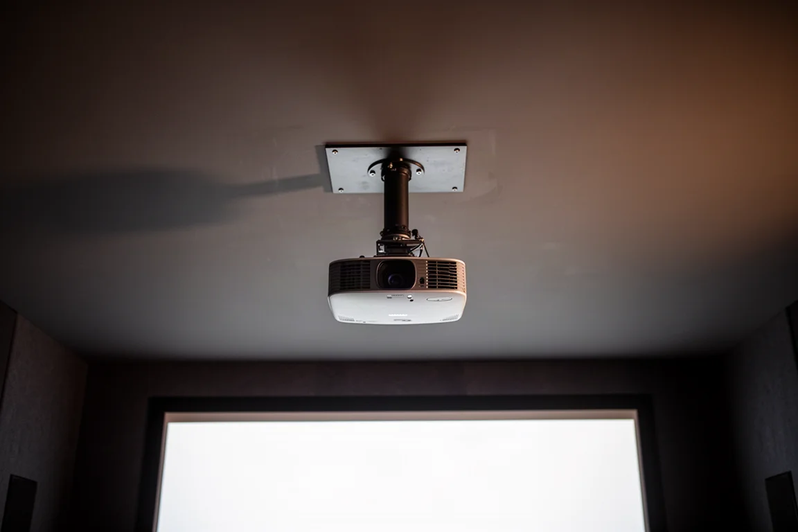 Plaque de plafond et ensemble de tube d'extension au-dessus d'un projecteur monté dans une pièce sombre