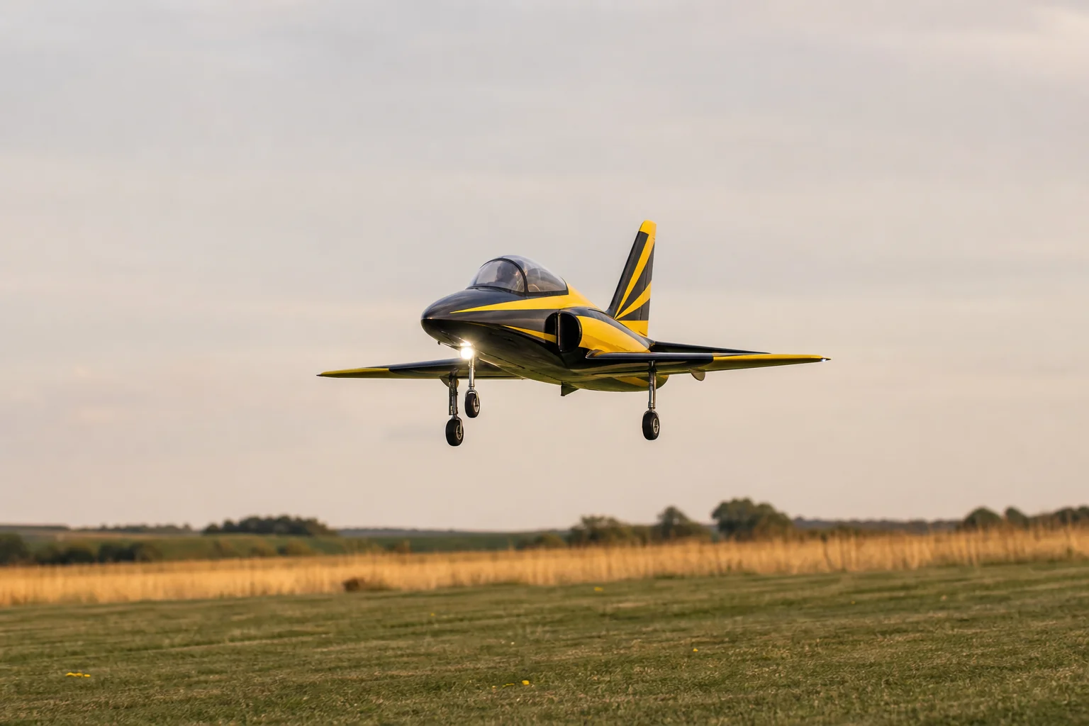 Jet RC en aproximación final a una pista de hierba con el tren de aterrizaje extendido