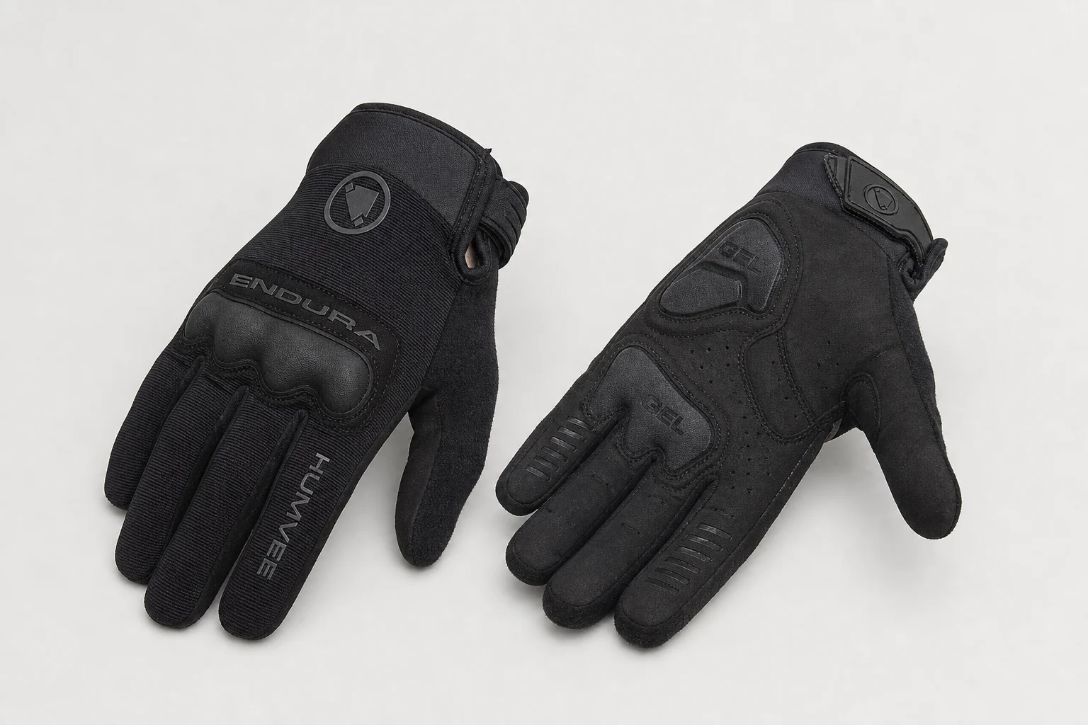 Five mountain bike gloves arranged on concrete showing different designs and protection levels