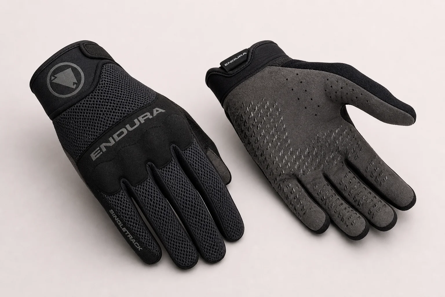 Five mountain bike gloves arranged on concrete showing different designs and protection levels
