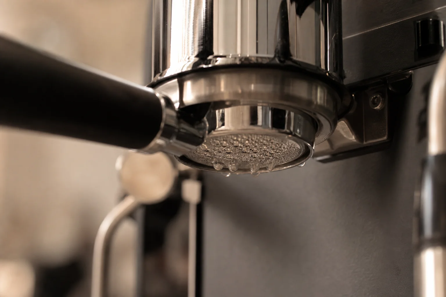 Close-up of espresso machine group head with portafilter locked in position