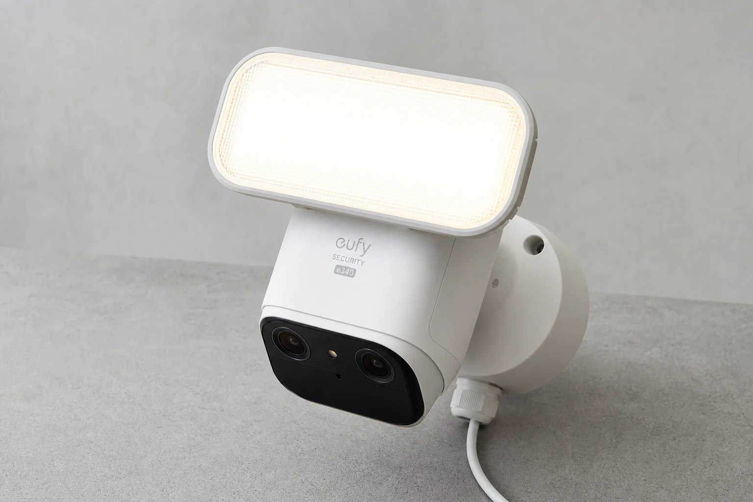Eufy security camera system devices including HomeBase 3, doorbell, pan-tilt camera, and floodlight on concrete