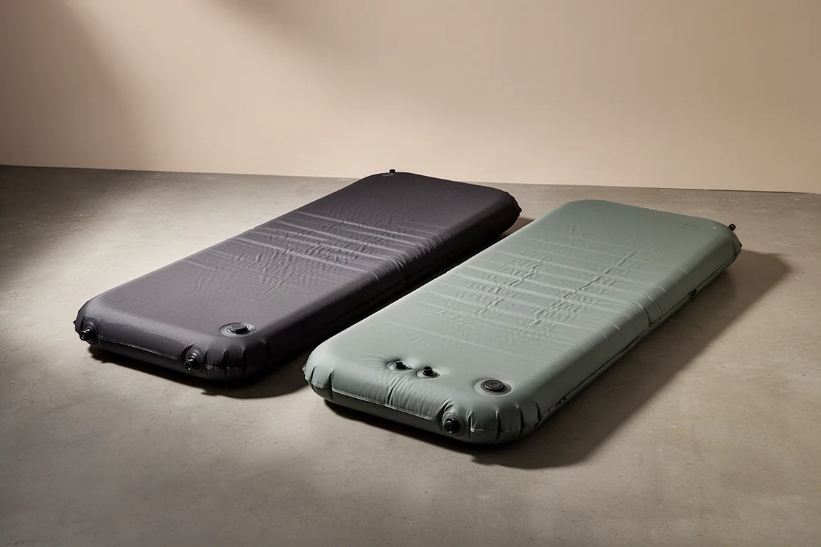 Two self-inflating double sleeping pads side by side on a concrete floor