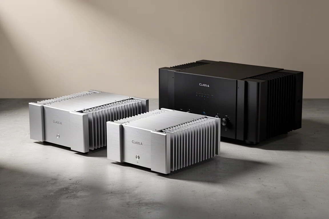 Three high-end Class A audio amplifiers on a matte concrete surface in soft studio light