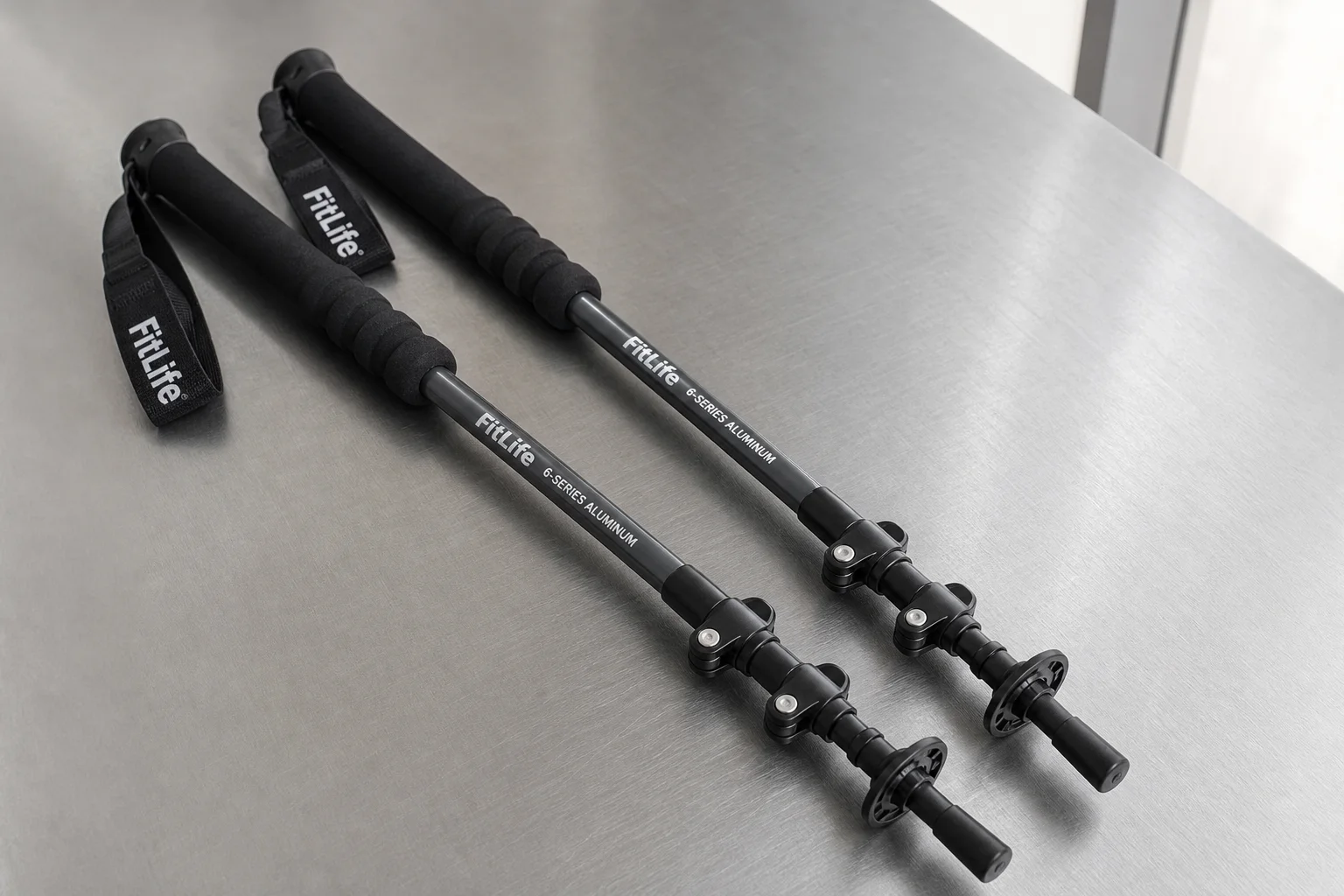 Five trekking poles in different styles arranged on concrete surface