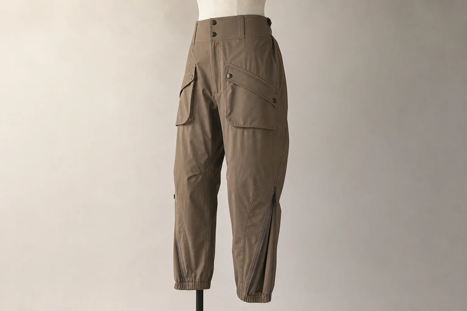 Five hiking pants in different styles displayed side by side on neutral backdrop