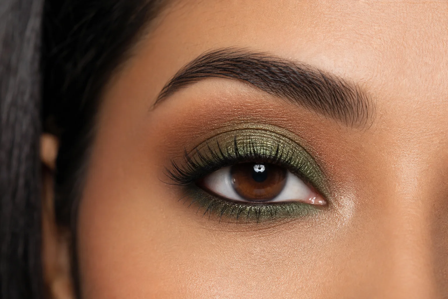 Completed eye makeup featuring green eyeshadow with shimmer and blended lower lash line
