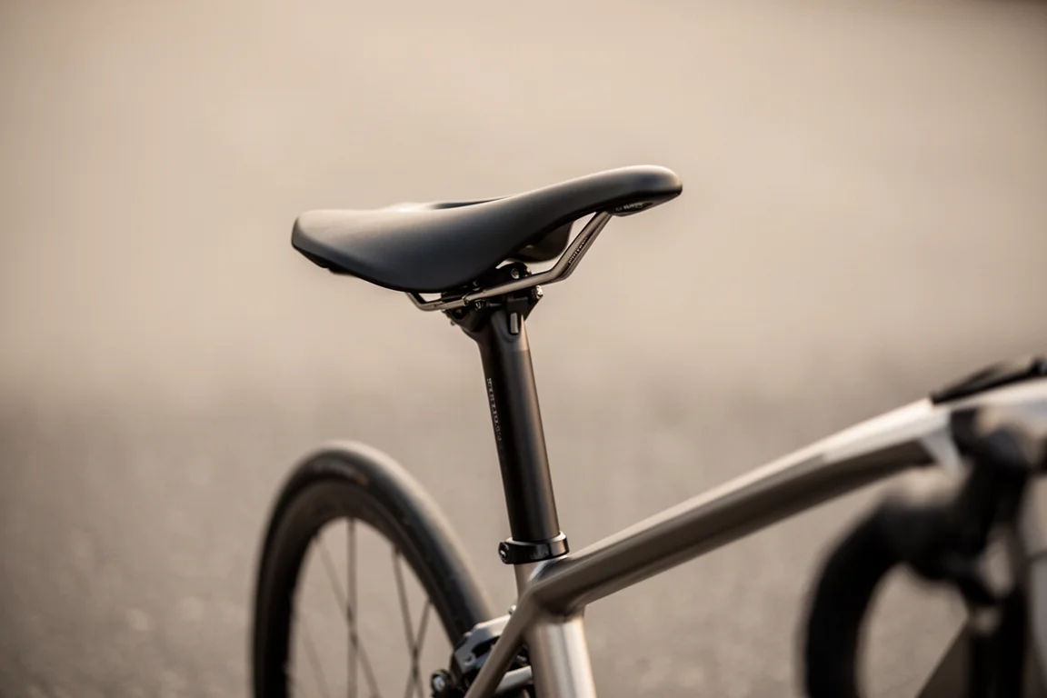 Vista posteriore di sella e reggisella di bici da strada su superficie stradale sfocata