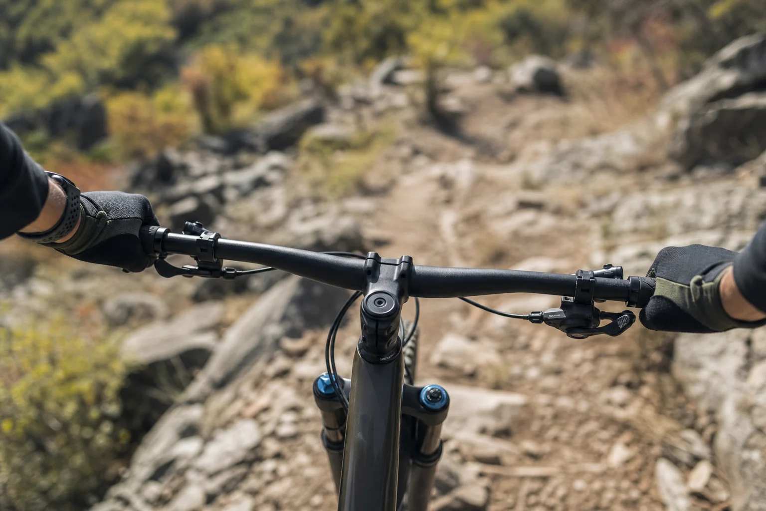 Mountainbiker greift auf einem felsigen Trail den Lenker