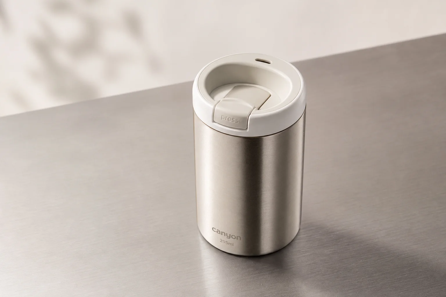 Acht wiederverwendbare Kaffeebecher auf einer Betonoberfläche, die verschiedene Materialien und Designs zeigen