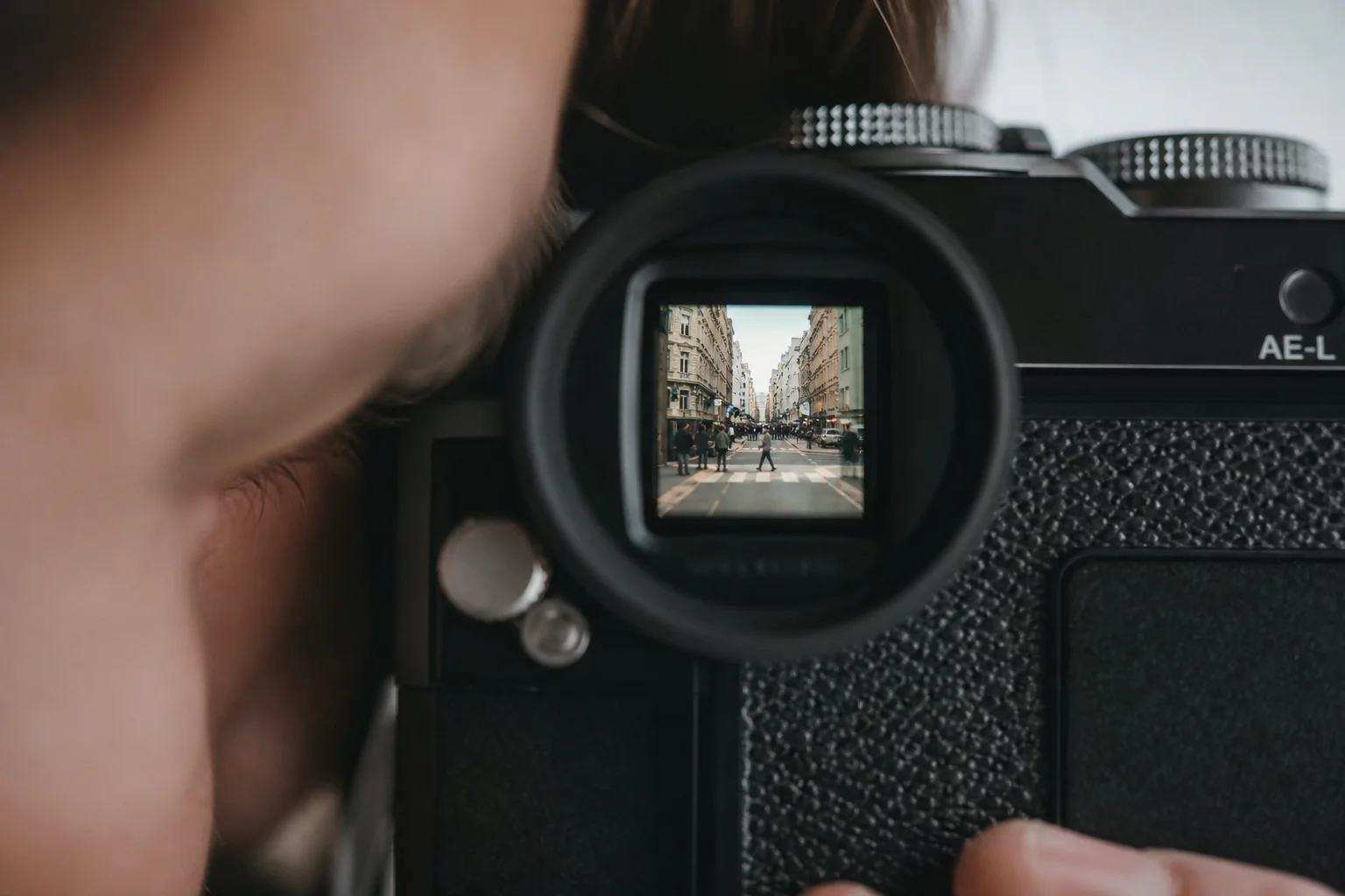 Photographer framing a scene through an optical viewfinder