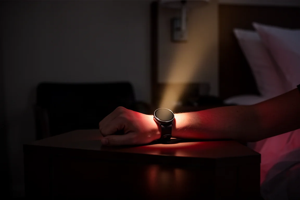 Smartwatch flashlight beam illuminating a dark hotel room floor