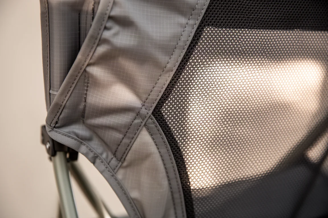 Primo piano del tessuto ripstop e di un pannello in mesh sullo schienale di una sedia da campeggio pieghevole