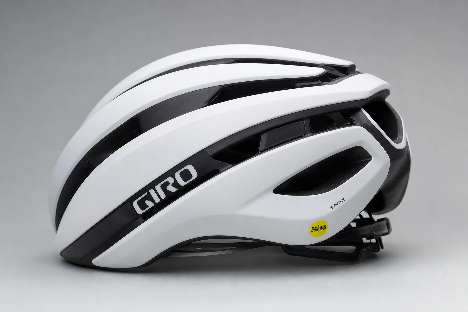 Five road bike helmets arranged in a row on concrete surface showing different designs