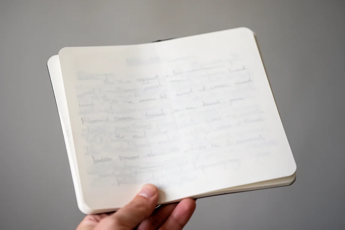 Reverso de una página escrita de la libreta mostrando una leve translucidez bajo la luz de una lámpara