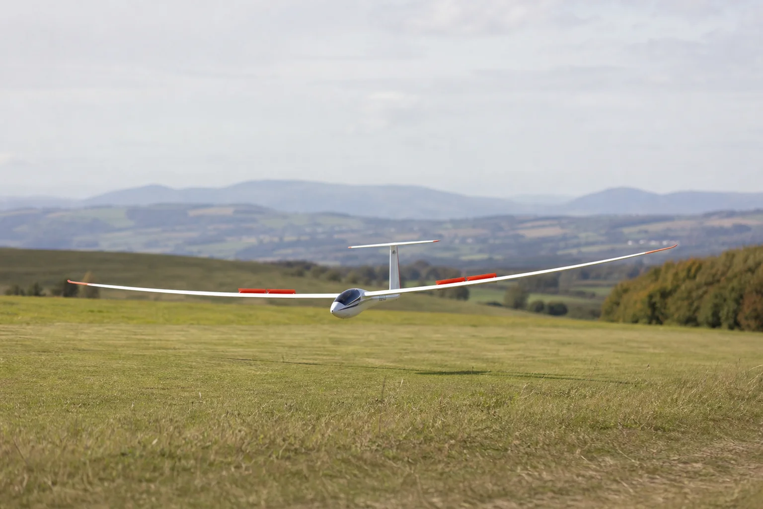 RC glider landing approach with spoilers extended on grass field