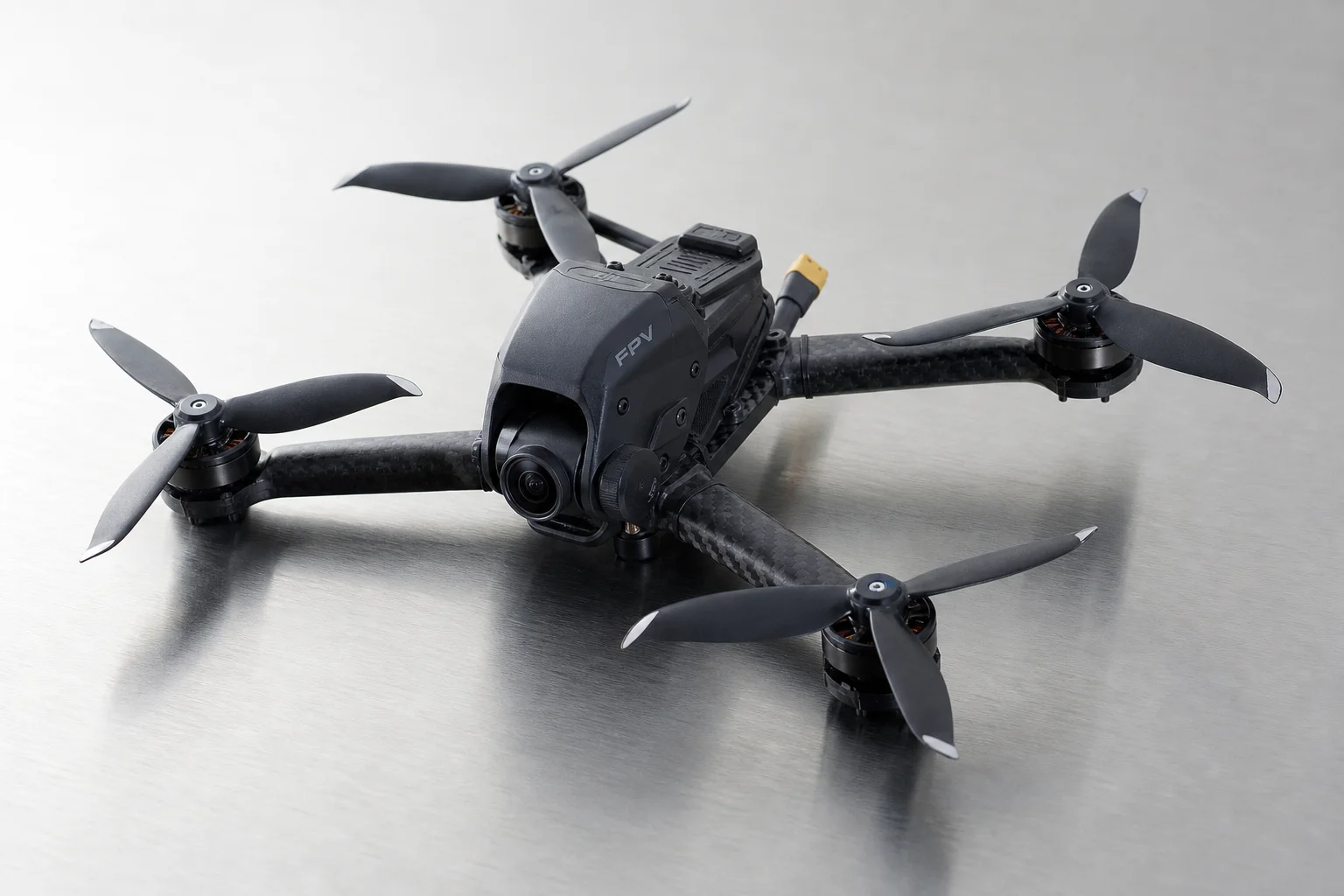 Cinq drones d'entrée de gamme disposés sur une surface en béton gris