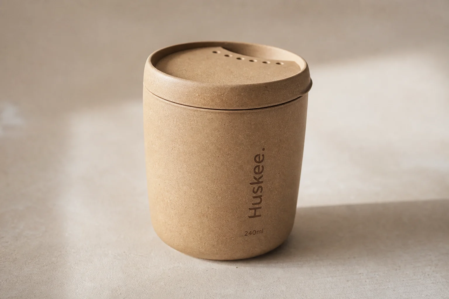 Acht wiederverwendbare Kaffeebecher auf einer Betonoberfläche, die verschiedene Materialien und Designs zeigen