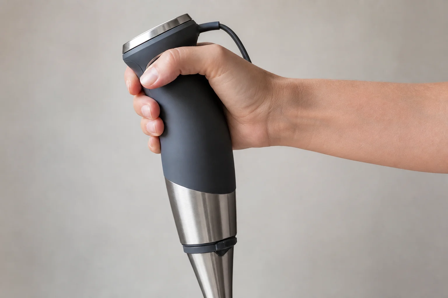 Hand greift den ergonomischen, gummibeschichteten Griff des Stabmixers
